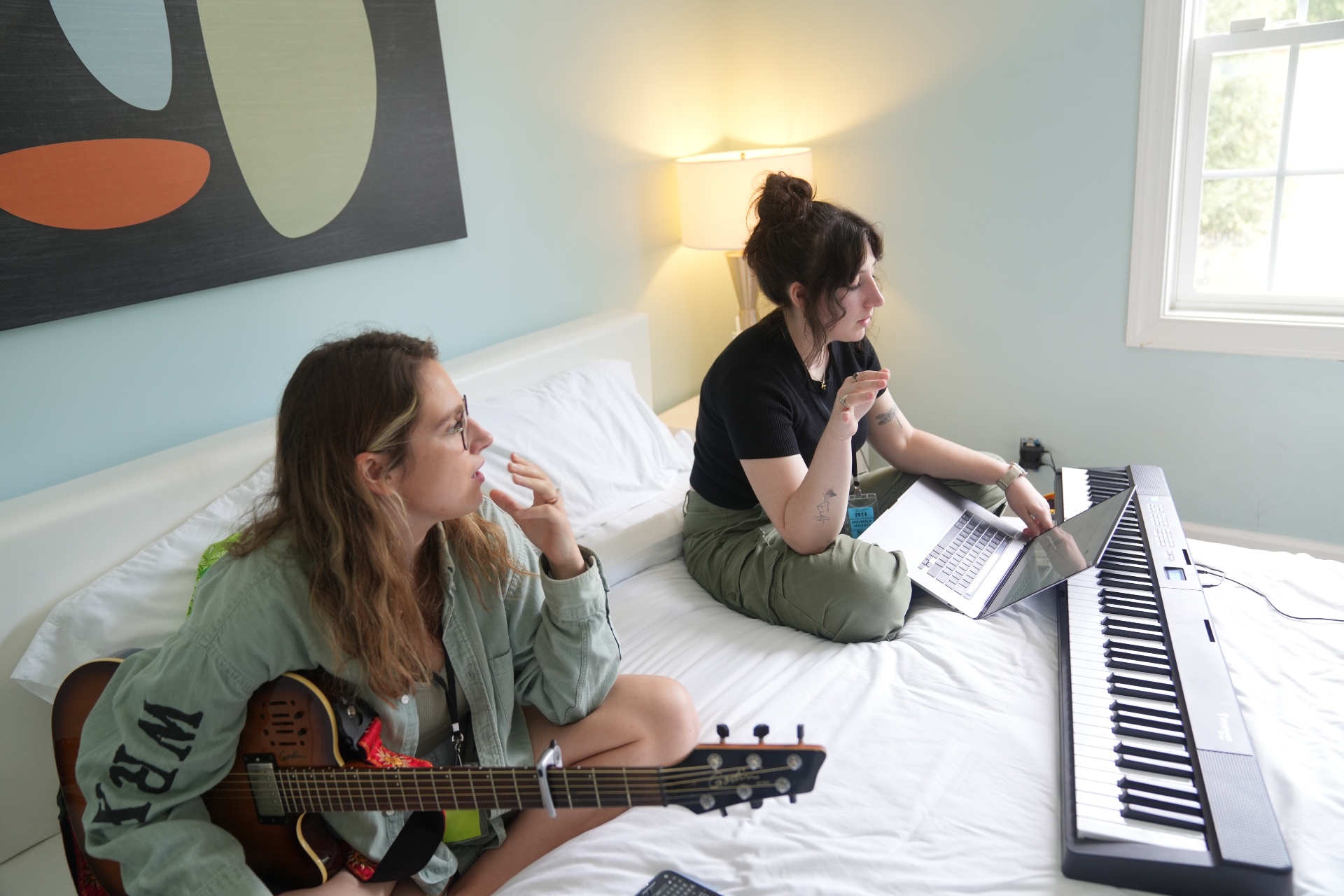 A songwriter writing alone at home with a guitar